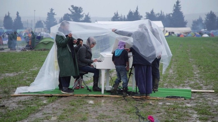 Concert émouvant d`une refugiée syrienne sous la pluie à la frontière gréco-macédonienne - VIDEO